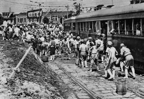 土砂で埋まった車両を掘り出す勤労奉仕団の青年たち